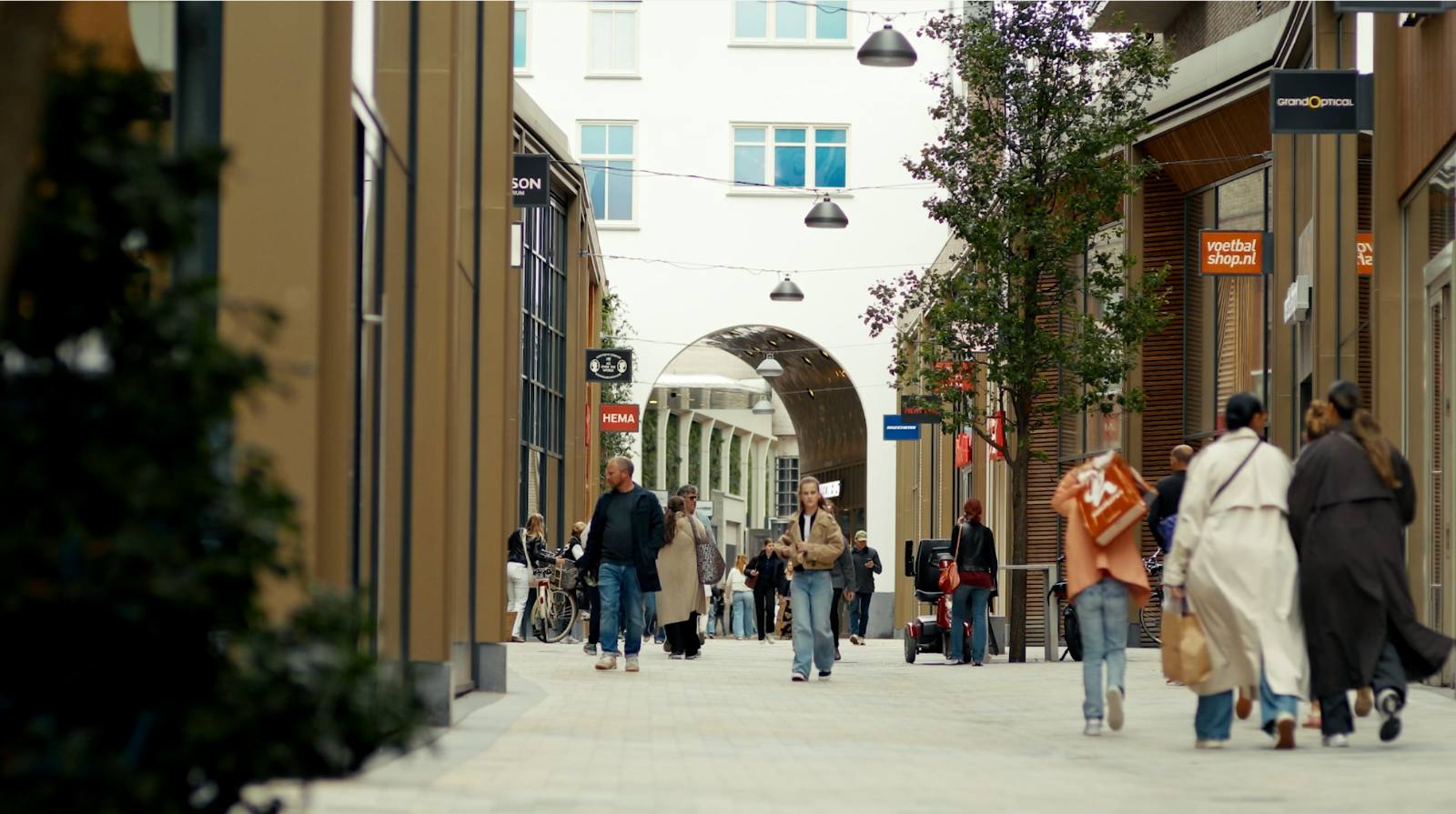 Mensen lopen door een levendige, autovrije winkelstraat