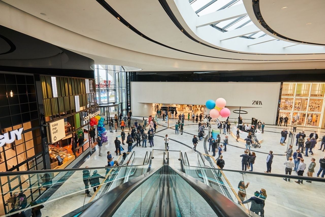 Het centrale atrium met roltrappen en winkelend publiek