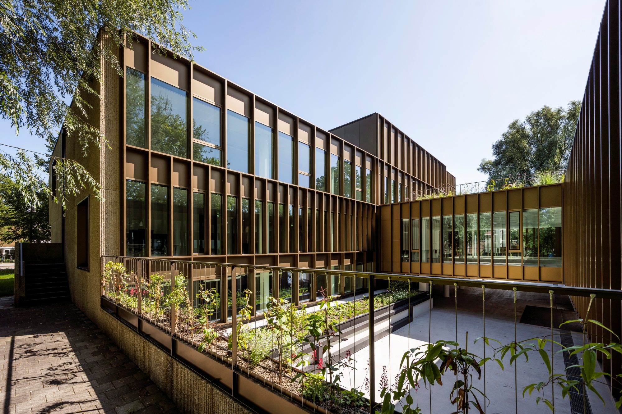 Het terras met beplanting langs de kantoorvleugel