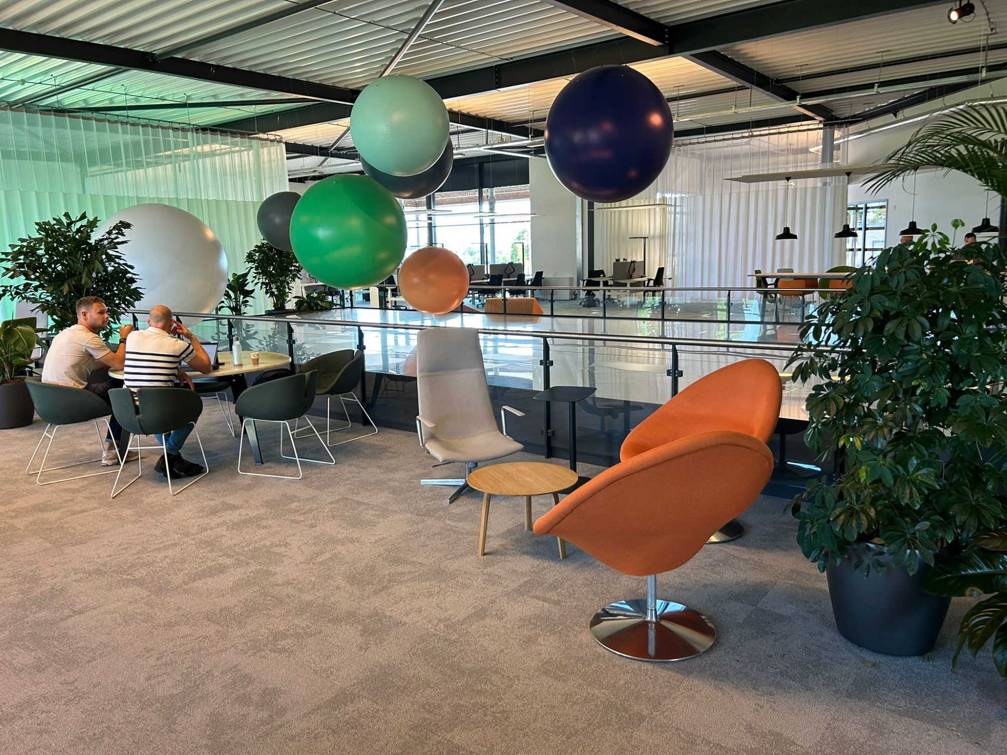 De lounge met zitplekken en beplanting op de bedrijfsvloer